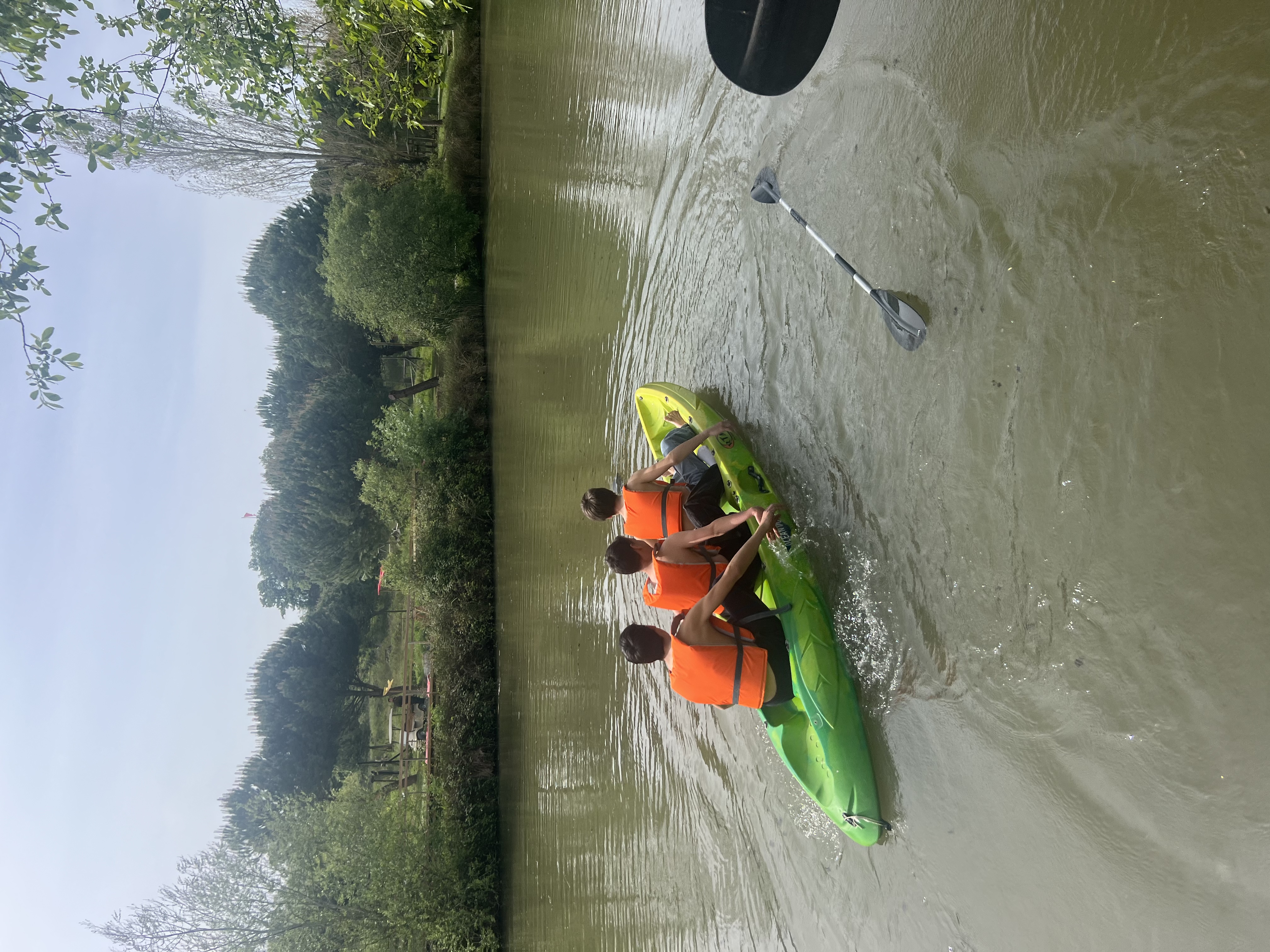 3 jovens em canoas no rio